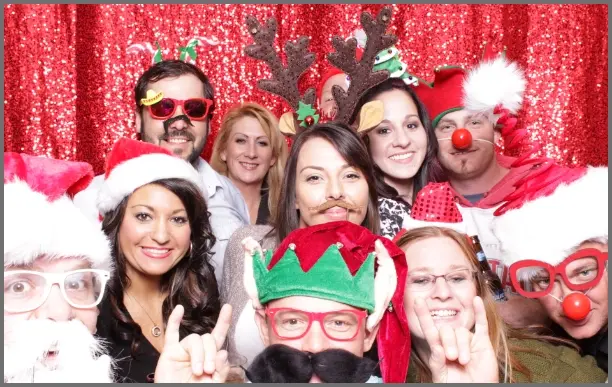 Family posing with holiday props at Christmas photo booth